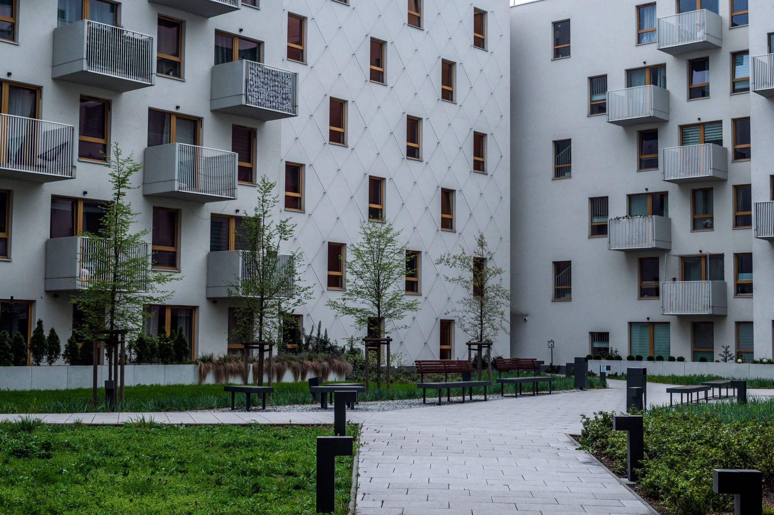 Peyzajlı yeşil avlunun çevresinde konumlanan modern apartman blokları